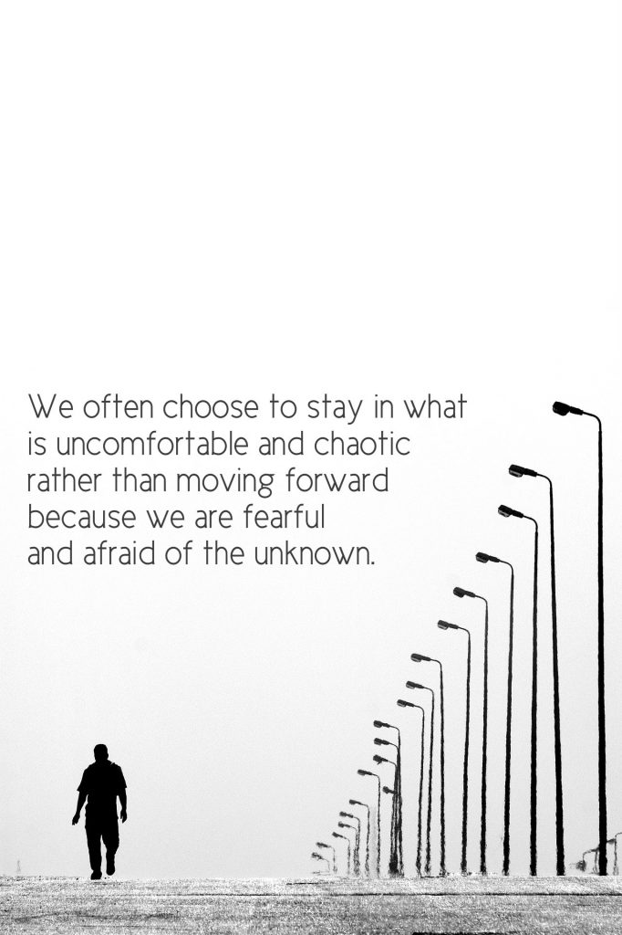 poster of man on lonely road: we often choose to stay in what is uncomfortable and chaotic rather than moving forward because we are fearful and afraid of the unknown. Quote by Tami Shahnawaz on post about exploring the self.