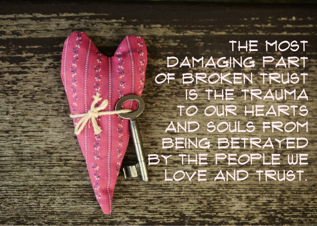 The most damaging part of broken trust is the trauma to our hearts and souls from being betrayed by the people we love and trust. Heart with key on wooden boards as background 