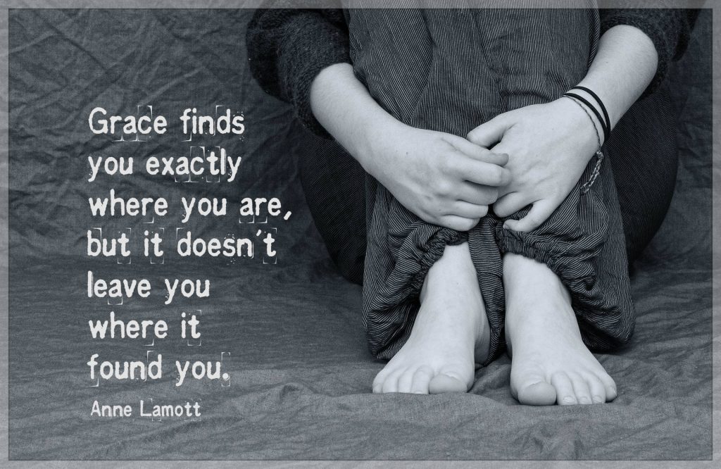 Grace finds you exactly where you are, but it doesn't leave you where it found you. Quote by Anne Lamott with pic of a woman sitting forlorn on ground, hands curled around her lower legs.