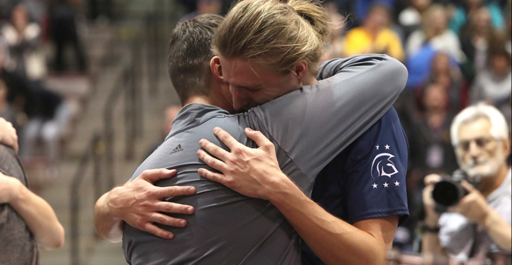 PHoto of a coach and player hugging after a National Championship loss